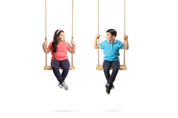 Little boy and girl on swings looking at each other