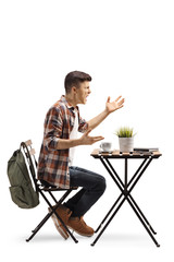 Full length profile shot of an angry male student in a cafe shouting isolated on white background