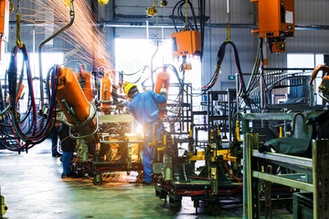 Welding robots movement in a car factory - obrazy, fototapety, plakaty