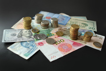 Closeup of silver and copper coins and banknotes of all states on a dark background