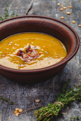 Pumpkin pea soup with bacon on wooden background. Close up