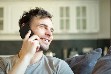 A man is talking on the phone and smiling at work