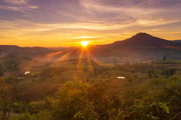 Beautiful landscape beam of light the sun is rising behind the mountain.