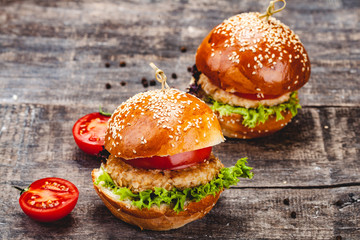 Chicken burgers on wooden background. Close up