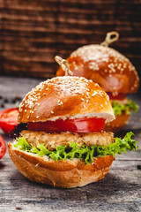 Chicken burgers on wooden background. Close up