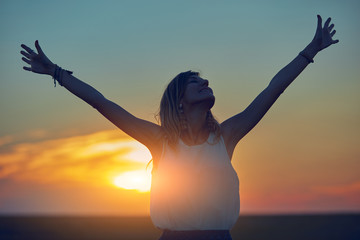 Cute young woman jumping in a wheat field.
