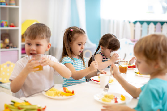 Group of kindergarten kids have lunch in daycare