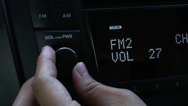 Close Up Of Asian Young Woman Turning On Radio  And  Adjust Music Sound Volume In Car. Auto Audio Concept