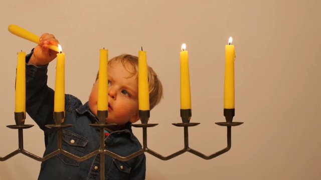 cute 2 years old boy ignite Menorah dolly shot
