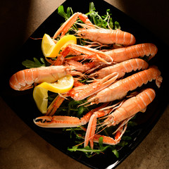 fresh grilled shrimps served on a plate with arugula or rocket and llemon
