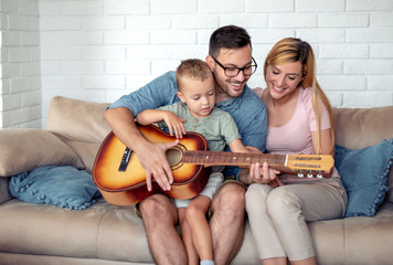 Happy family play guitar at home