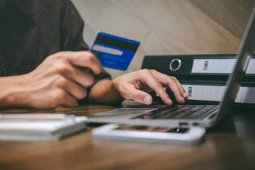 Businessman holding credit card and typing on laptop for online shopping and payment makes a purchase on the Internet, Online payment, Business financial and technology