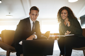 Young business colleagues using a laptop in an modern office