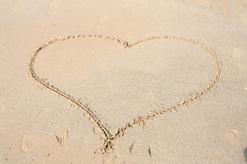 Shape of heart drawn on sandy beach. Concept of love, romantic relationship