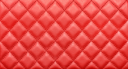Close-up texture of genuine leather with rhombic stitching. Saturated red color - obrazy, fototapety, plakaty