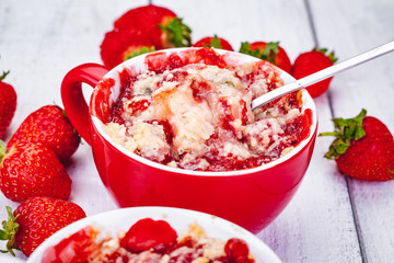 Strawberry crumble in cup on wooden rustic table. Close up