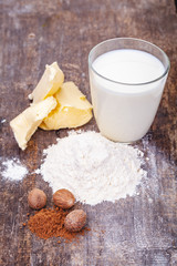Ingredients for preparing white bechamel sauce on wooden table. Close up