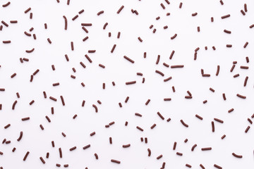 Fototapeta na wymiar flat lay of chocolate sprinkles over white background like background, top view