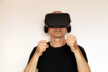 Close-up of a man in a black T-shirt with glasses of virtual reality.