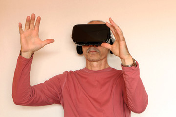 Close-up of a man in a pink T-shirt with glasses of virtual reality.
