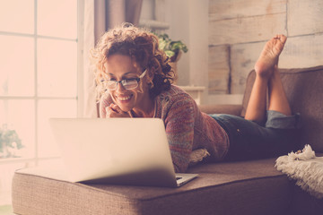 Woman smile and use an internet laptop connected to watch a movie or work easy at home in alternative office and lifestyle concept - freelance and free people with technology
