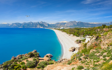 Naklejka premium Widok z lotu ptaka na piękną błękitną zatokę i plażę Konyaalti w popularnym kurorcie Antalya, Turcja.