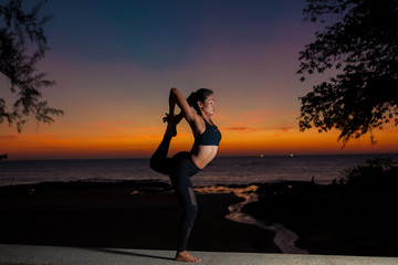 Fototapeta na wymiar silhouette practicing yoga on sunset