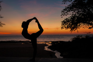 woman  silhouette playing yoga on sunset background