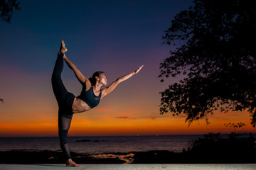  woman  silhouette practicing yoga with sunset background