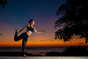 woman  silhouette practicing yoga