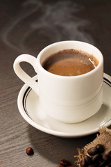 Coffee cup and coffee beans on wooden background