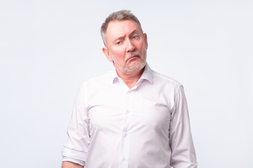 Fototapeta premium Old senior man in white shirt with serious and sad expression.