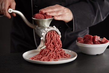 Man making minced meat with manual grinder