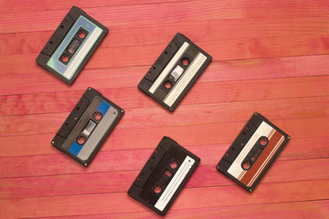 audio cassettes tape lay on pink wooden plank