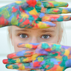 Fashionable model girl with multicolored hands near the face