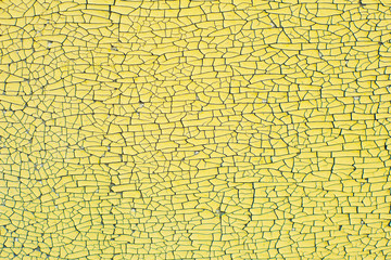 Painted yellow old wall with peeling paint. Texture. Cracks	