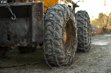 Fototapeta na wymiar Snow tire chains on big truck wheel