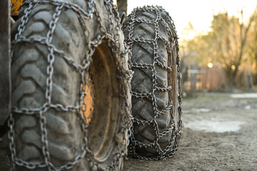 Fototapeta na wymiar Snow tire chains on big truck wheel