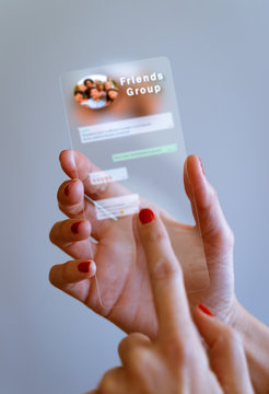 Woman hand holding transparent futuristic smartphone with Messaging app on screen. Social media, business, technology and people concept