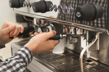 Cropped shot of a professional barista preparing coffee at his coffee shop working with coffee machine equipment profession occupation brewing beverage morning aromatic drink service preparation conce