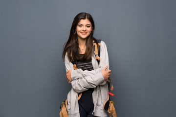 Teenager traveler girl over wall keeping the arms crossed in frontal position