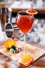 Orange cocktail in a beautiful glass on a high stem with an orange slice in a beautiful composition...