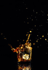 Isolated shot of whiskey with splash on black background