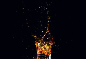 Isolated shot of whiskey with splash on black background