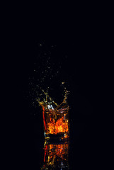 Isolated shot of whiskey with splash on black background
