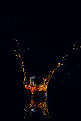 Isolated shot of whiskey with splash on black background