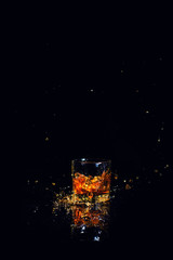 Isolated shot of whiskey with splash on black background