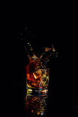 Isolated shot of whiskey with splash on black background