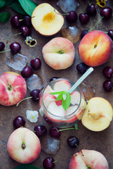 Cocktail with organic fresh peaches and cherries