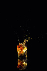 Isolated shot of whiskey with splash on black background